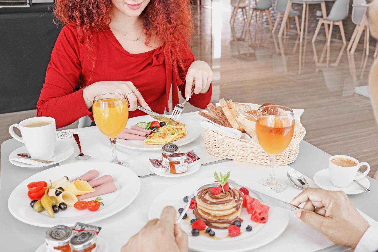 The Bentley Luxury Hotel & Suites 도하 외부 사진 A woman eating breakfast